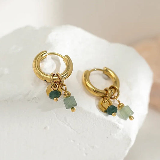 Goldene Creolen mit grünen Edelstein-Anhängern, eleganter Schmuck, modische Ohrringe.