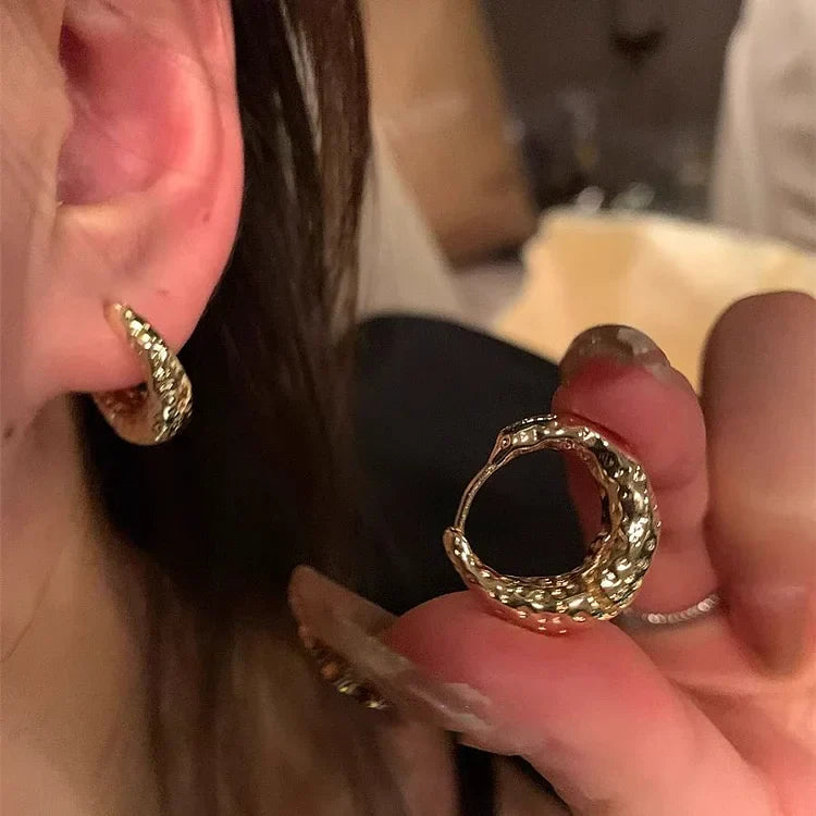 Goldene Creolen Ohrringe, strukturiert, modisch, Damen Schmuck, Nahaufnahme.