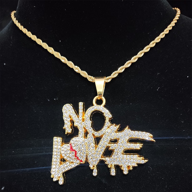Goldene Halskette mit "NO LOVE"-Anhänger, besetzt mit Strasssteinen, auf schwarzem Hintergrund.