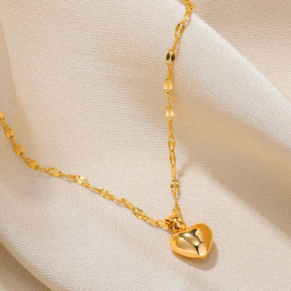 Goldene Herz-Halskette auf beigem Stoff, elegantes Schmuckdesign, Damenaccessoire.