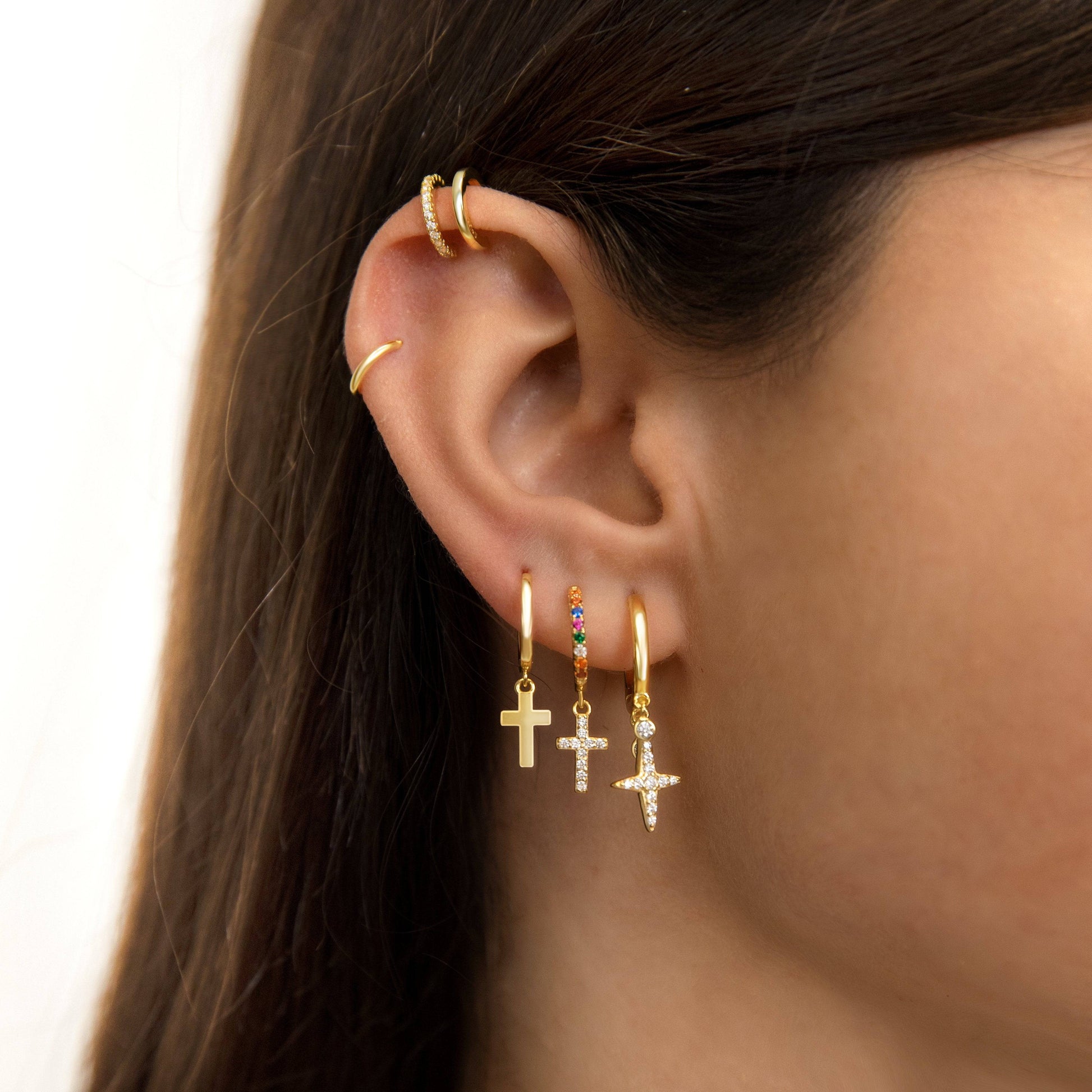 Frau mit goldenen Creolen und Kreuzanhängern, Ohrschmuck, modische Ohrringe, Schmucktrends.