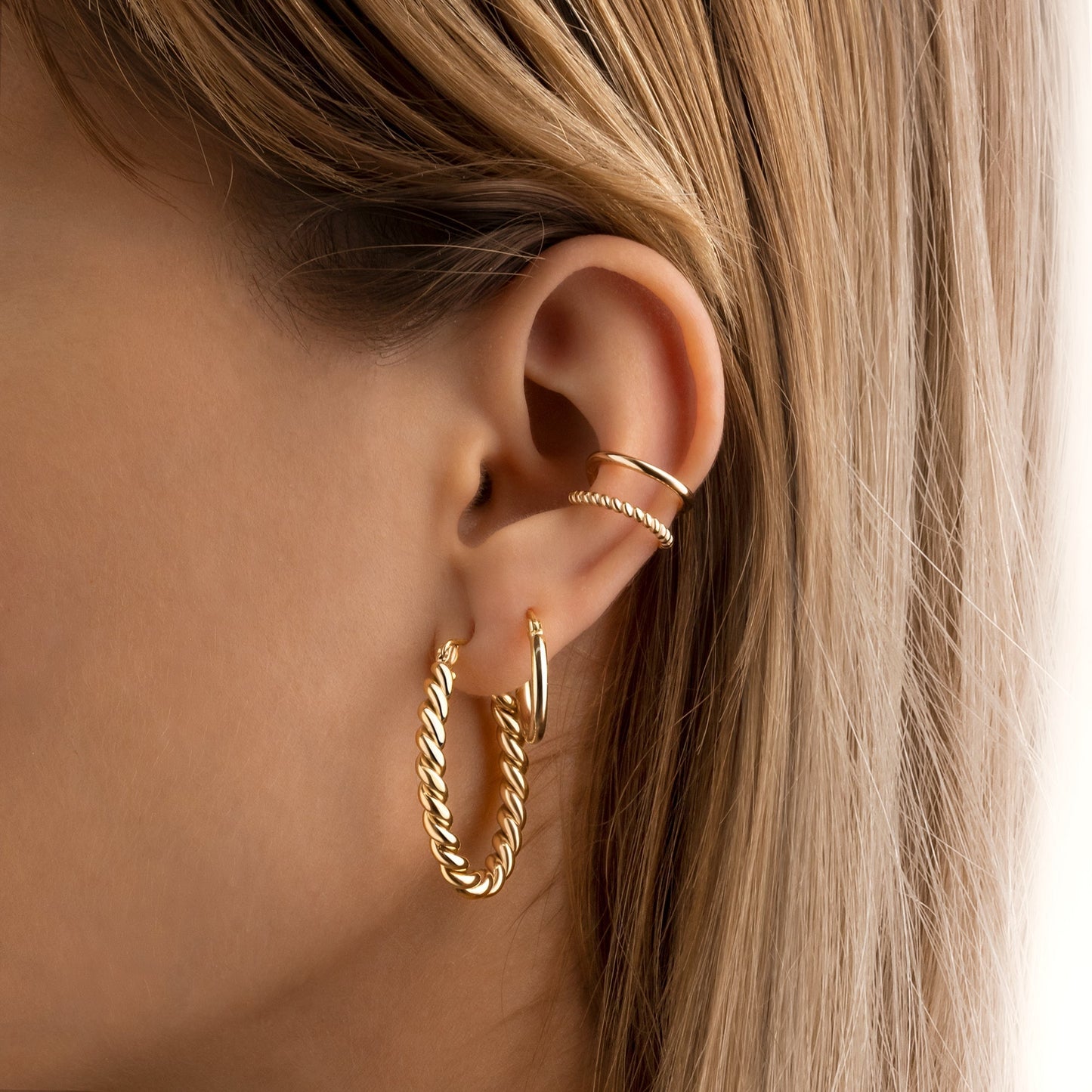 Frau mit goldenen Creolen und Ohrsteckern, Schmuck, Modeaccessoire, elegantes Design