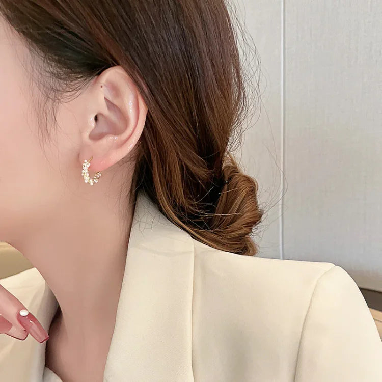 Frau mit goldenen Ohrringen, eleganter Schmuck, Nahaufnahme, modisches Accessoire, Damenmode.