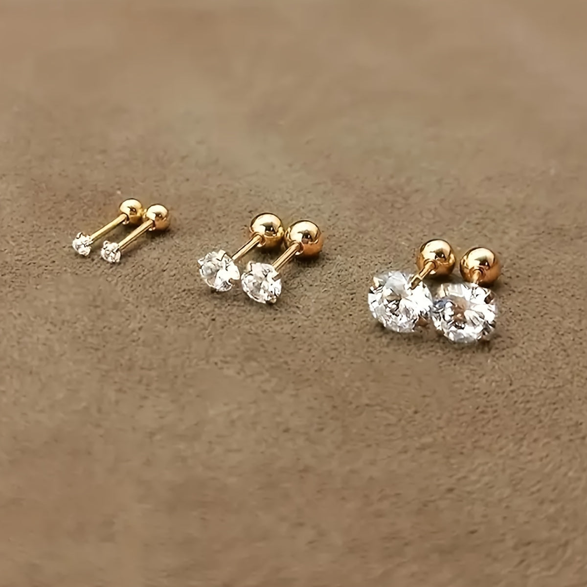 Goldene Ohrstecker mit klaren Zirkonia, verschiedene Größen, eleganter Schmuck für Damen.