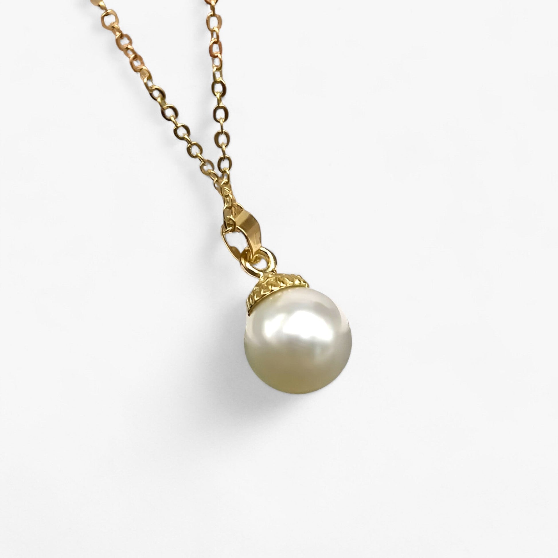 Goldene Halskette mit weißem Perlenanhänger, eleganter Schmuck, Damenaccessoire.