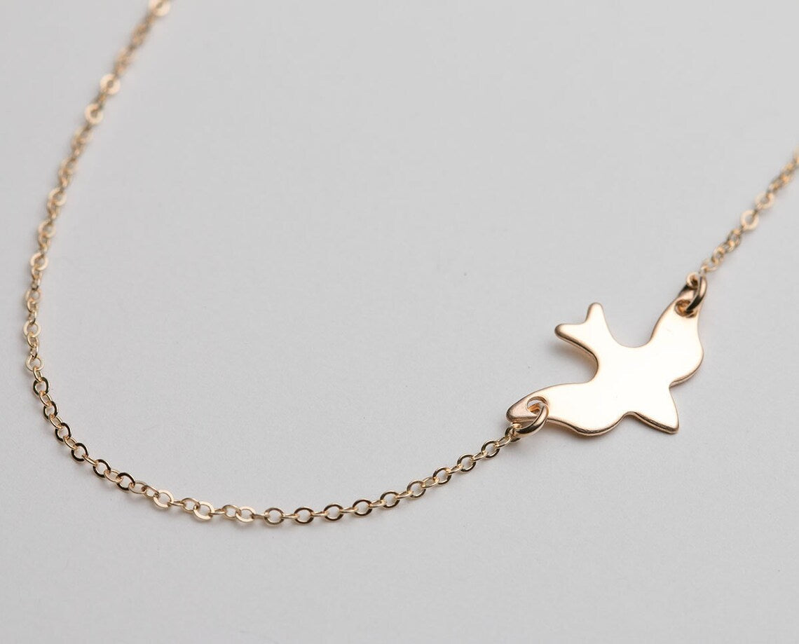 Goldene Halskette mit Taubenanhänger, filigranes Design, eleganter Schmuck für Damen.