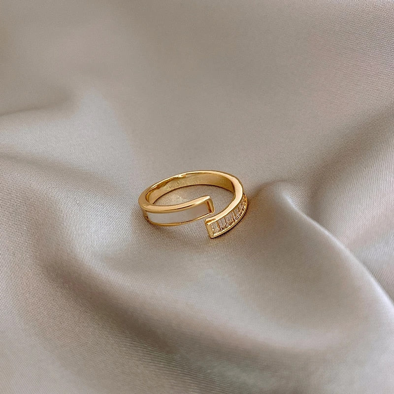 Goldener Ring mit Diamanten auf beigem Satin, elegantes Schmuckdesign, luxuriöses Accessoire.