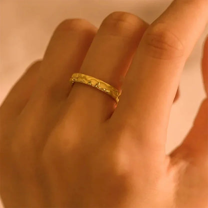 Goldener Damenring mit strukturiertem Design, eleganter Schmuck, modisches Accessoire.