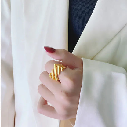 Goldener Ring, Damenmode, elegantes Design, Schmuck, Accessoire, stilvoll, Hand, weißer Blazer.