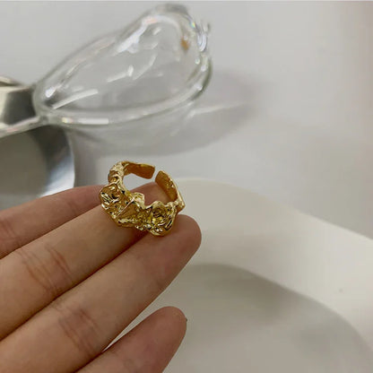 Goldener, strukturierter Ring auf Finger, Schmuckdesign, luxuriös, modisch, Damenaccessoire.