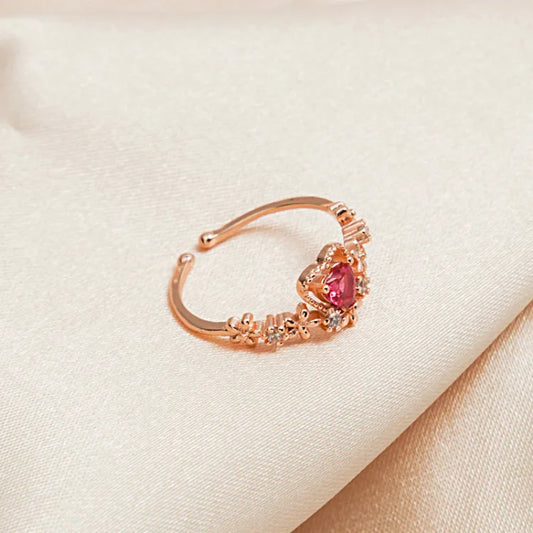 Goldener Ring mit rotem Herzstein, Blumenmuster, Damenmode, Schmuck, elegantes Design.