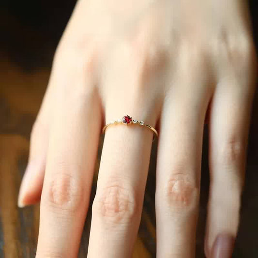 Goldener Ring mit rotem Edelstein auf Hand, eleganter Schmuck, Damenring, feine Details.