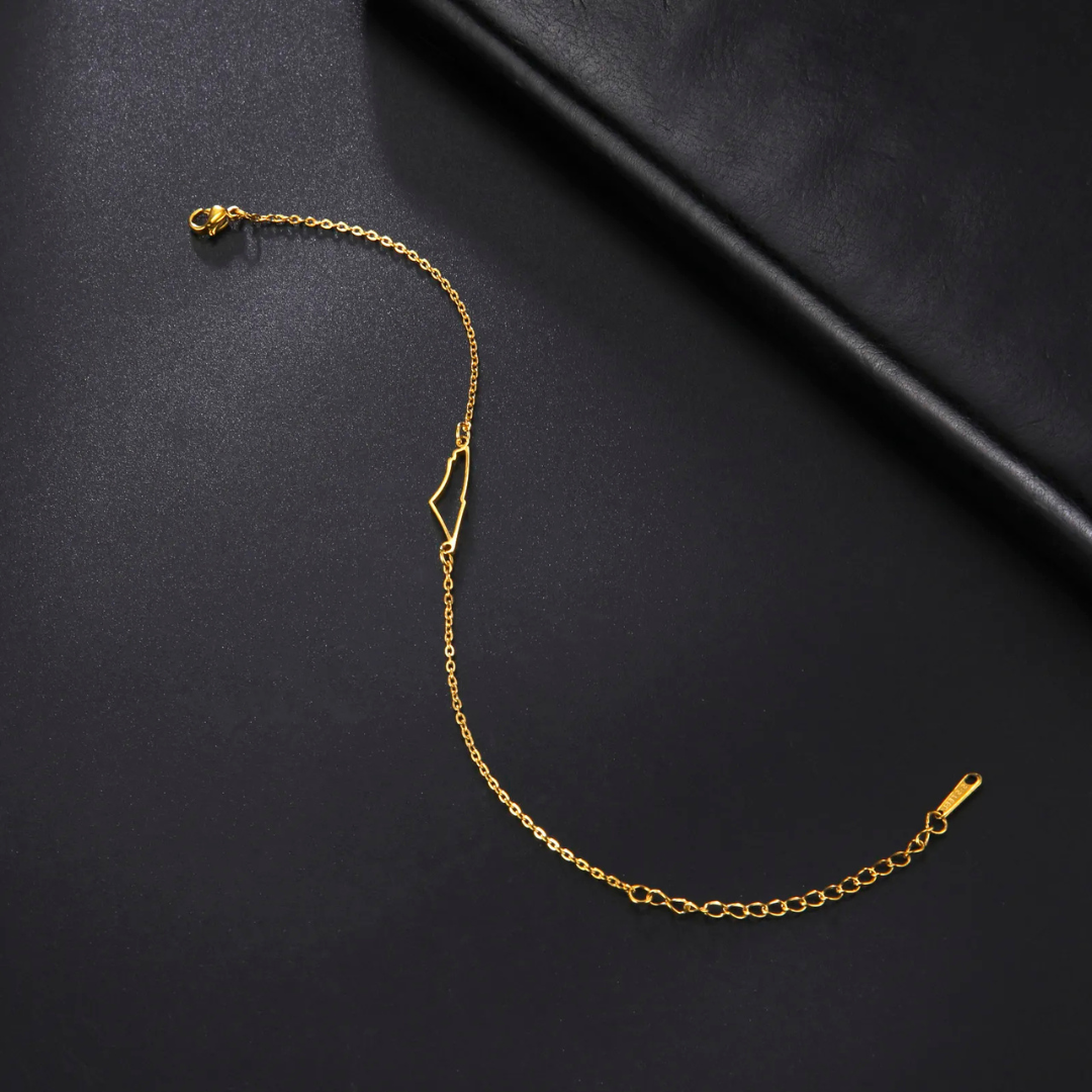 Goldene Armbandkette aus Edelstahl auf schwarzem Hintergrund, minimalistisches Design.