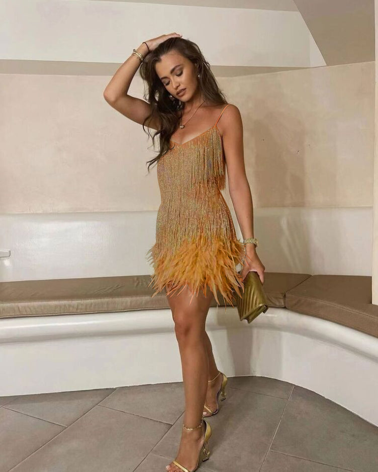 Frau in goldfarbenem Paillettenkleid mit Fransen, elegantes Abendoutfit, modisch, stilvoll.