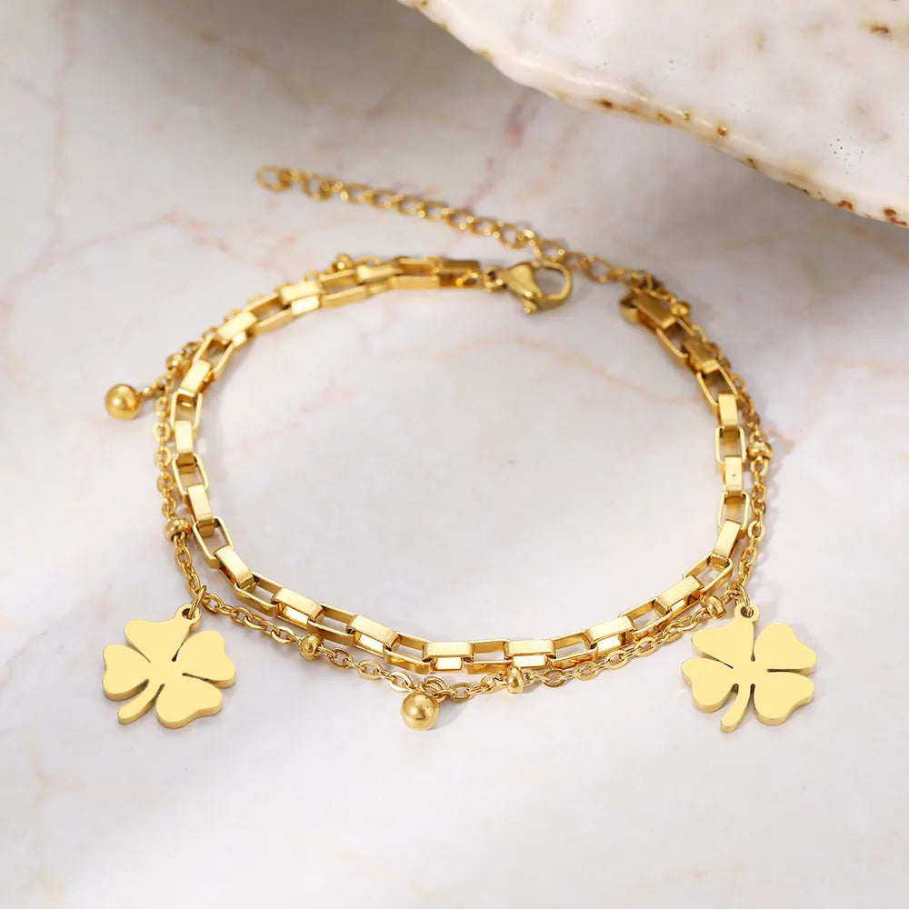 Goldenes Armband mit Kleeblatt-Anhänger, Edelstahl, verstellbar, modisches Schmuckstück.