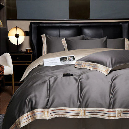Luxuriöse graue Bettwäsche-Set aus Satin mit Kissenbezügen und dekorativen Streifen im Schlafzimmer.