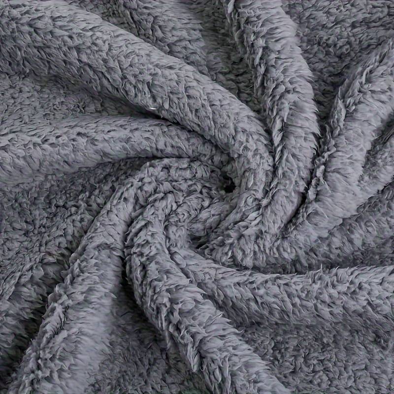Grauer Plüschstoff, weiche Textur, ideal für Decken und Kissen, gemütlich und warm.