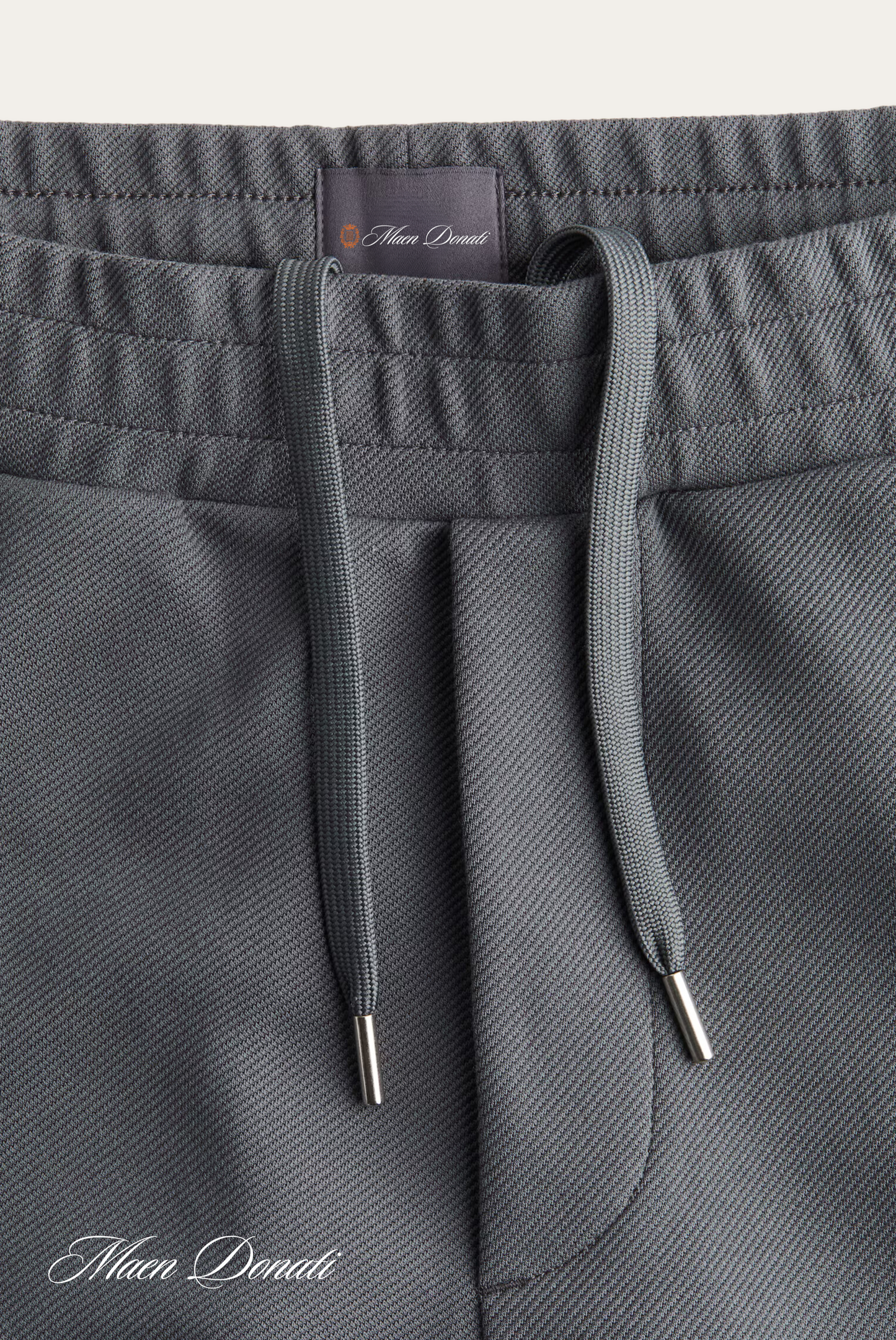 Graue Jogginghose mit Kordelzug, Mikrofaser, bequem, sportlich, Herrenmode, Nahaufnahme.