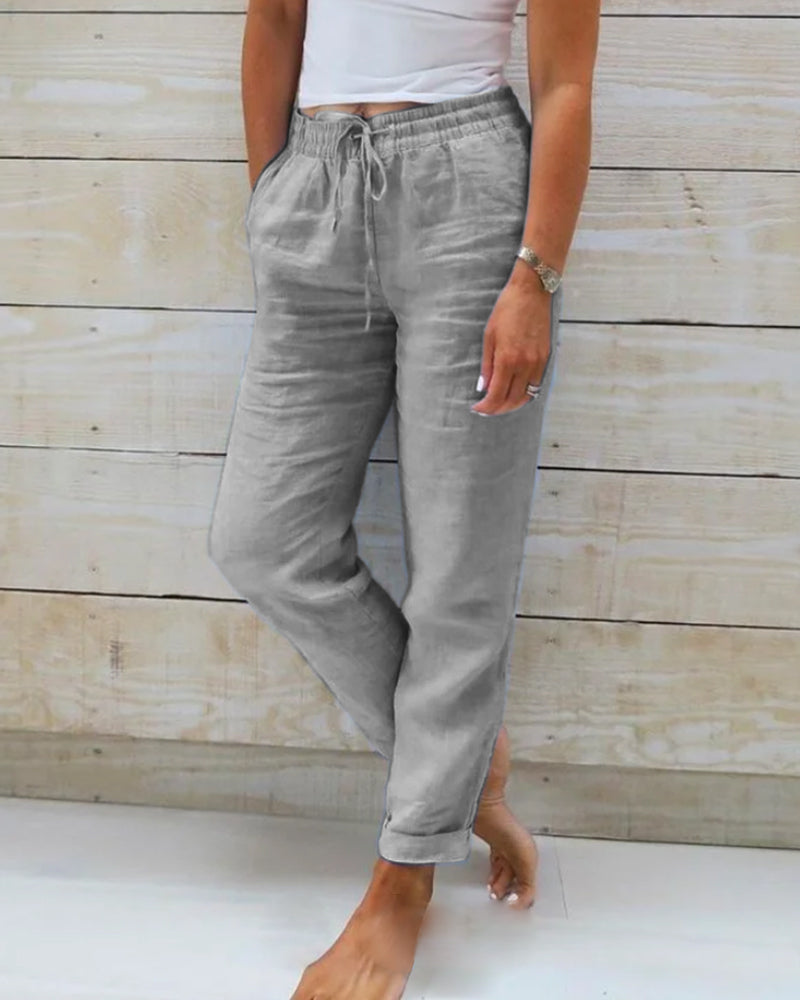 Frau trägt graue Leinenhose, lässig, bequem, mit Taschen, ideal für Sommermode.