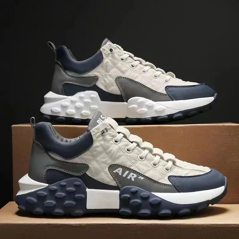 Graue und blaue Sneaker, Herren, mit dicker Sohle, modisch, sportlich, bequem, auf Karton.
