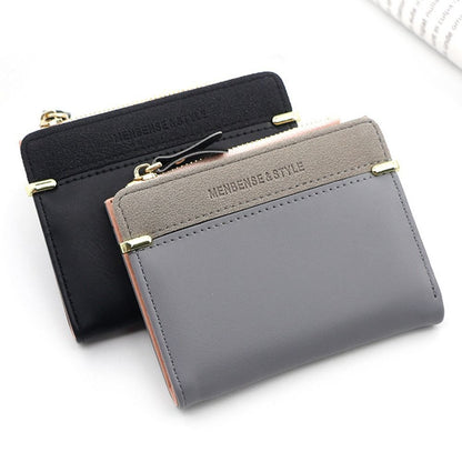 Graue und schwarze Mini-Kartenetuis aus Leder mit Reißverschluss und goldenen Details.