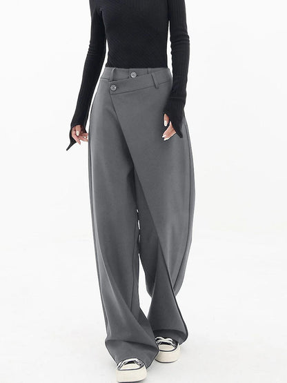 Frau in grauer, weiter Hose und schwarzem Oberteil, modisch, elegant, Streetwear-Look.