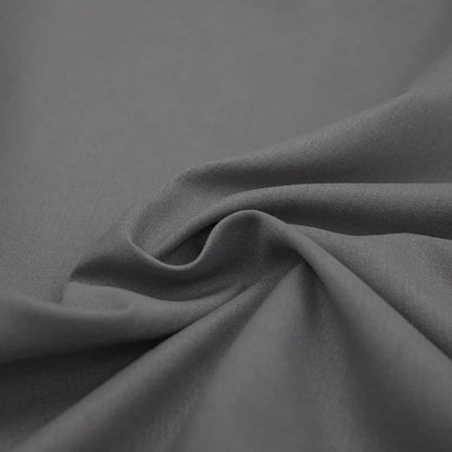 Grauer Baumwollstoff, weiche Textur, ideal für Bekleidung und Heimtextilien.