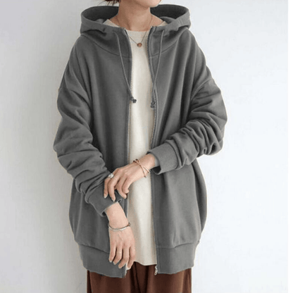 Frau in grauem Kapuzenpullover, lässiger Stil, bequeme Freizeitmode, Damenbekleidung.