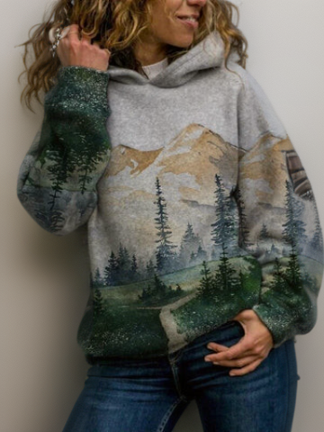 Frau trägt grauen Hoodie mit Berg- und Waldmotiv, Freizeitmode, Baumwolle, Damenbekleidung.