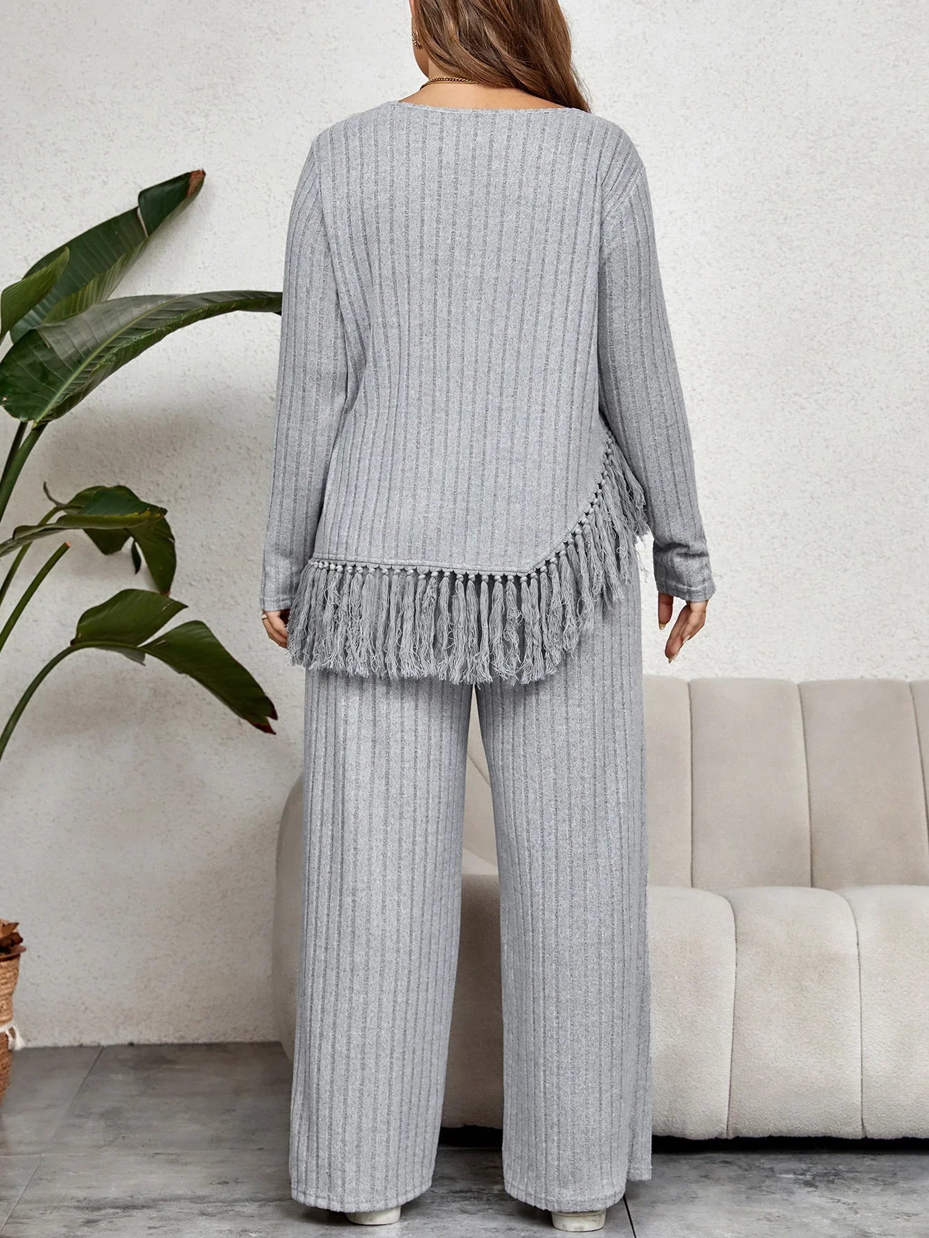 Frau in grauem Strick-Set mit Fransen, gemütliche Lounge-Mode, Herbst-Winter-Outfit.