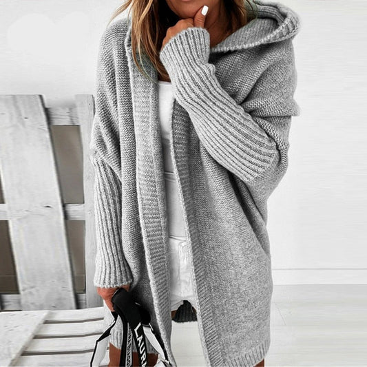 Frau in grauem Strick-Cardigan mit Kapuze, lässiger Stil, gemütliche Herbstmode.