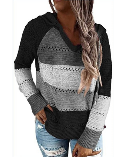 Frau in gestreiftem Strickpullover, schwarz-grau, mit Kapuze, lässiger Stil, Jeans.
