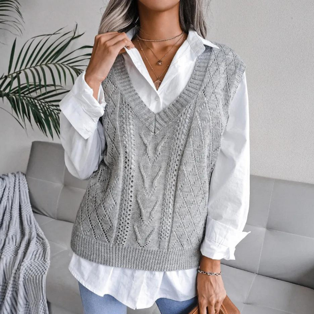 Frau trägt grauen Strickpullover über weißer Bluse, modisch, elegant, Herbstmode.