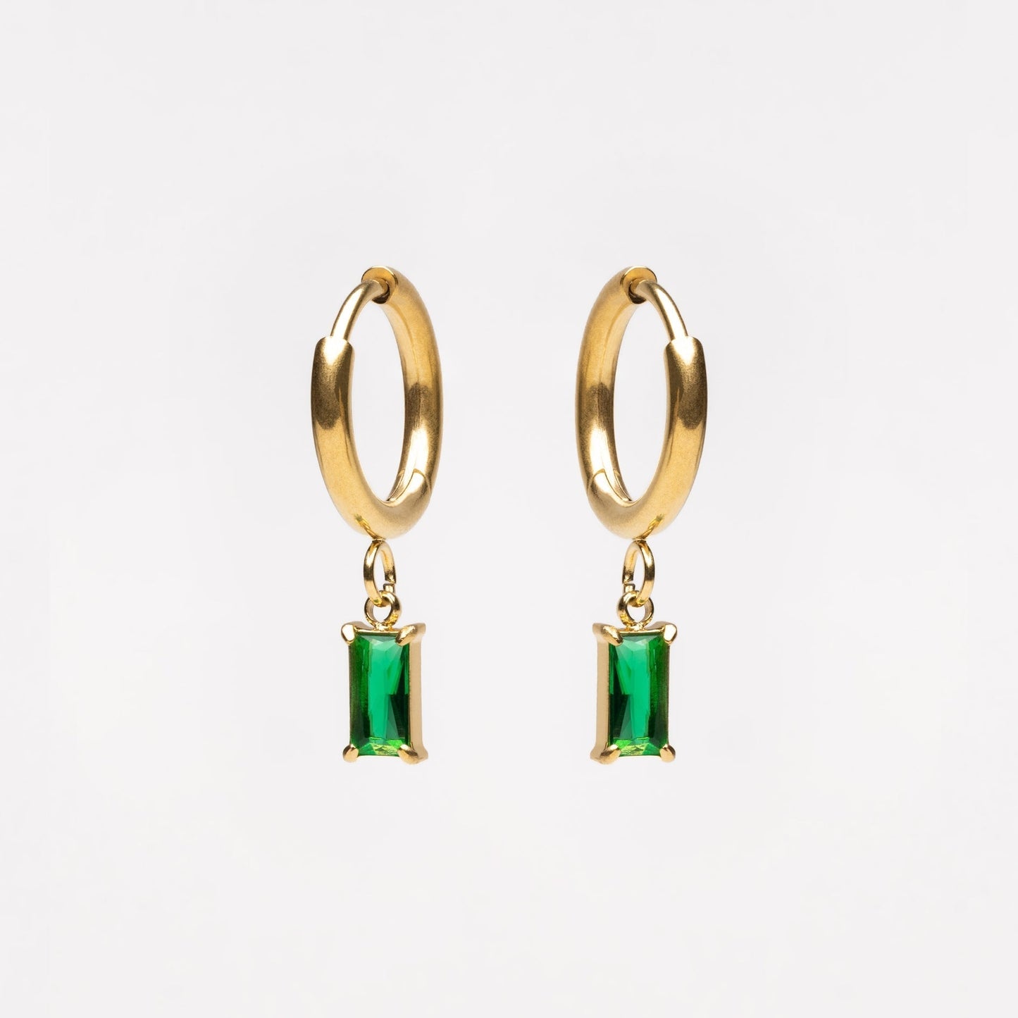 Goldene Creolen mit grünen rechteckigen Anhängern, eleganter Schmuck, modische Ohrringe.
