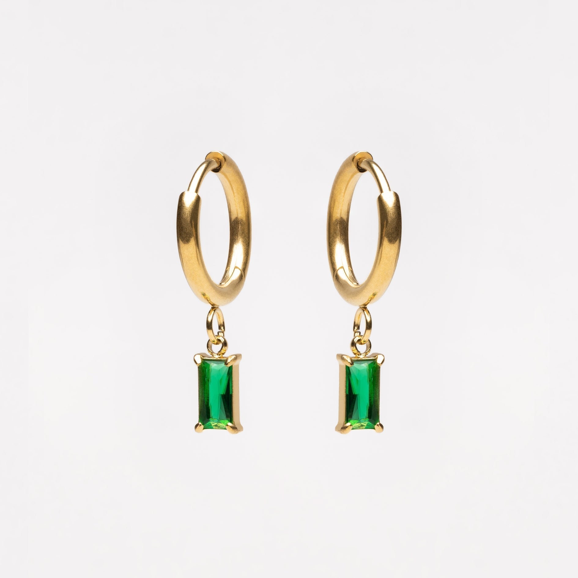 Goldene Creolen mit grünen rechteckigen Anhängern, eleganter Schmuck, modische Ohrringe.