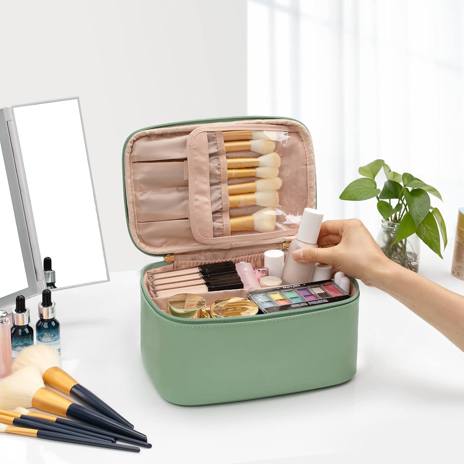 Grüne Kosmetiktasche mit Make-up-Pinseln und Schminkutensilien auf weißem Tisch.