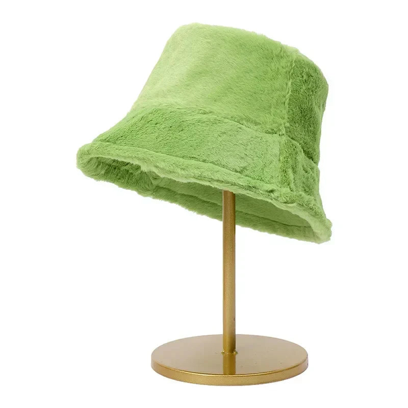 Grüner Kunstpelz-Bucket-Hut auf goldenem Ständer, modisches Accessoire.