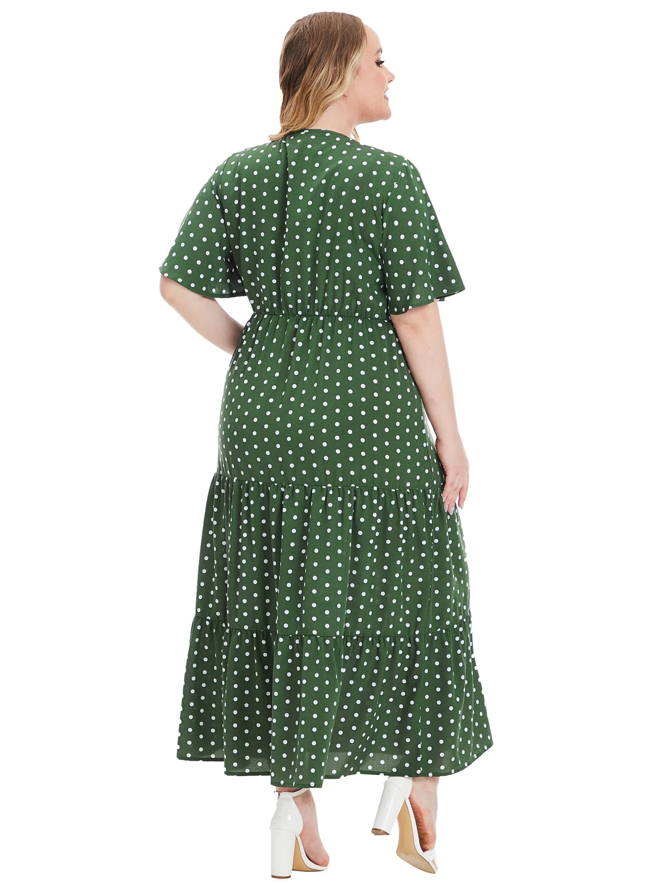 Frau in grünem gepunktetem Maxikleid aus Baumwolle, Rückansicht, modisch, elegant.