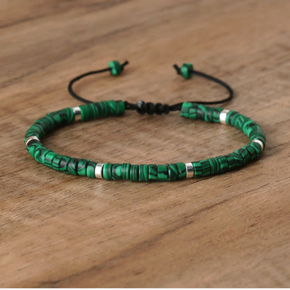 Grünes Perlenarmband aus Malachit mit verstellbarem Verschluss auf Holzoberfläche.