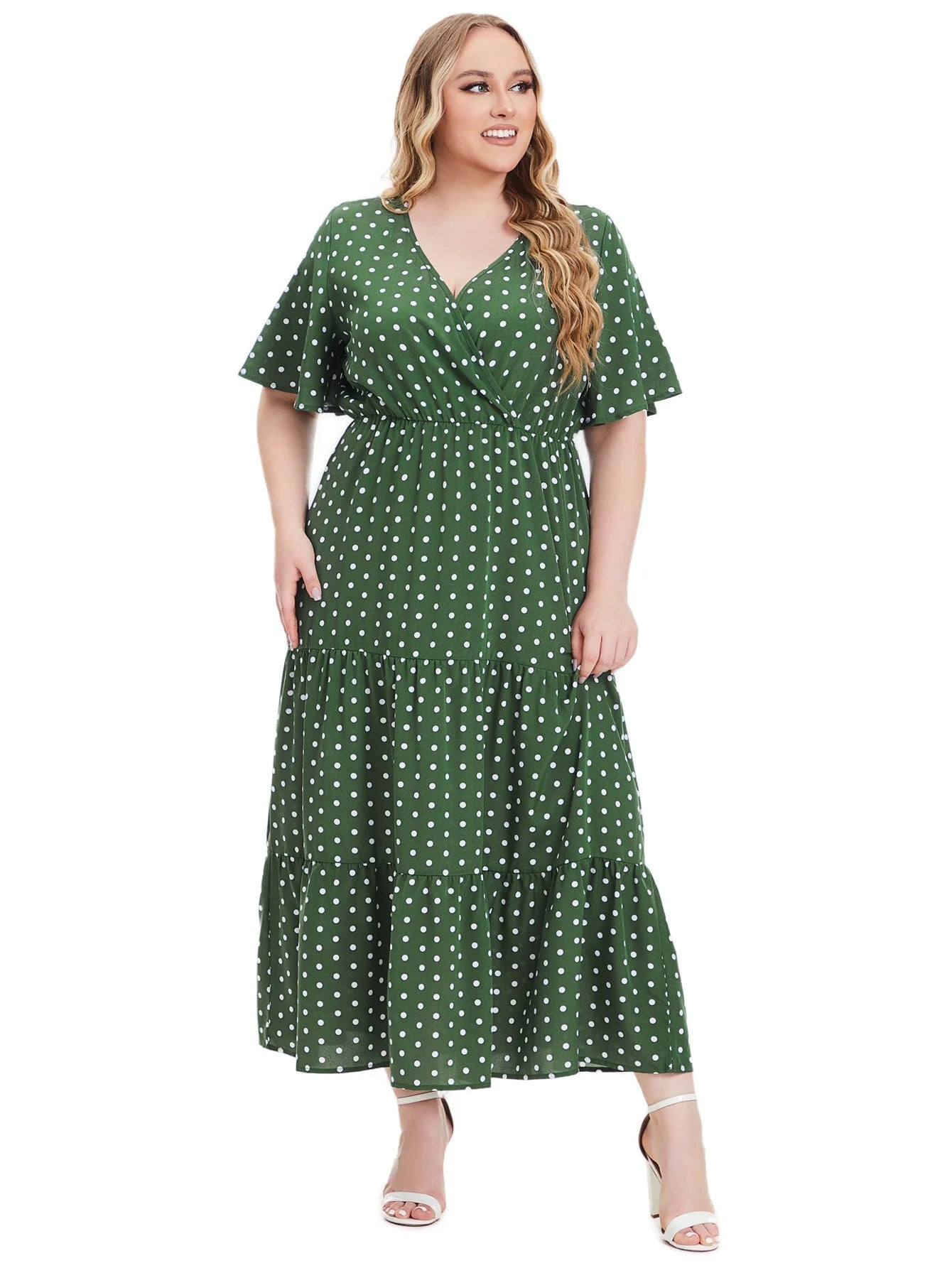 Frau im grünen gepunkteten Maxikleid, V-Ausschnitt, Plus-Size, Sommermode, elegant.