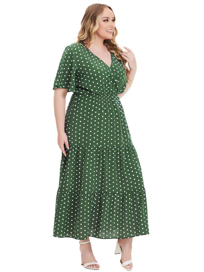 Frau im grünen gepunkteten Maxikleid, Plus-Size, Sommermode, elegant, weißer Hintergrund.