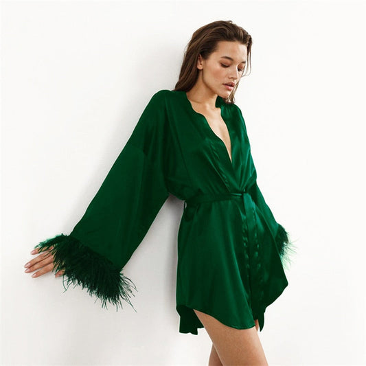 Frau in grünem Satin-Kimono mit Federn, elegantes Nachtwäsche-Outfit, Modefotografie.
