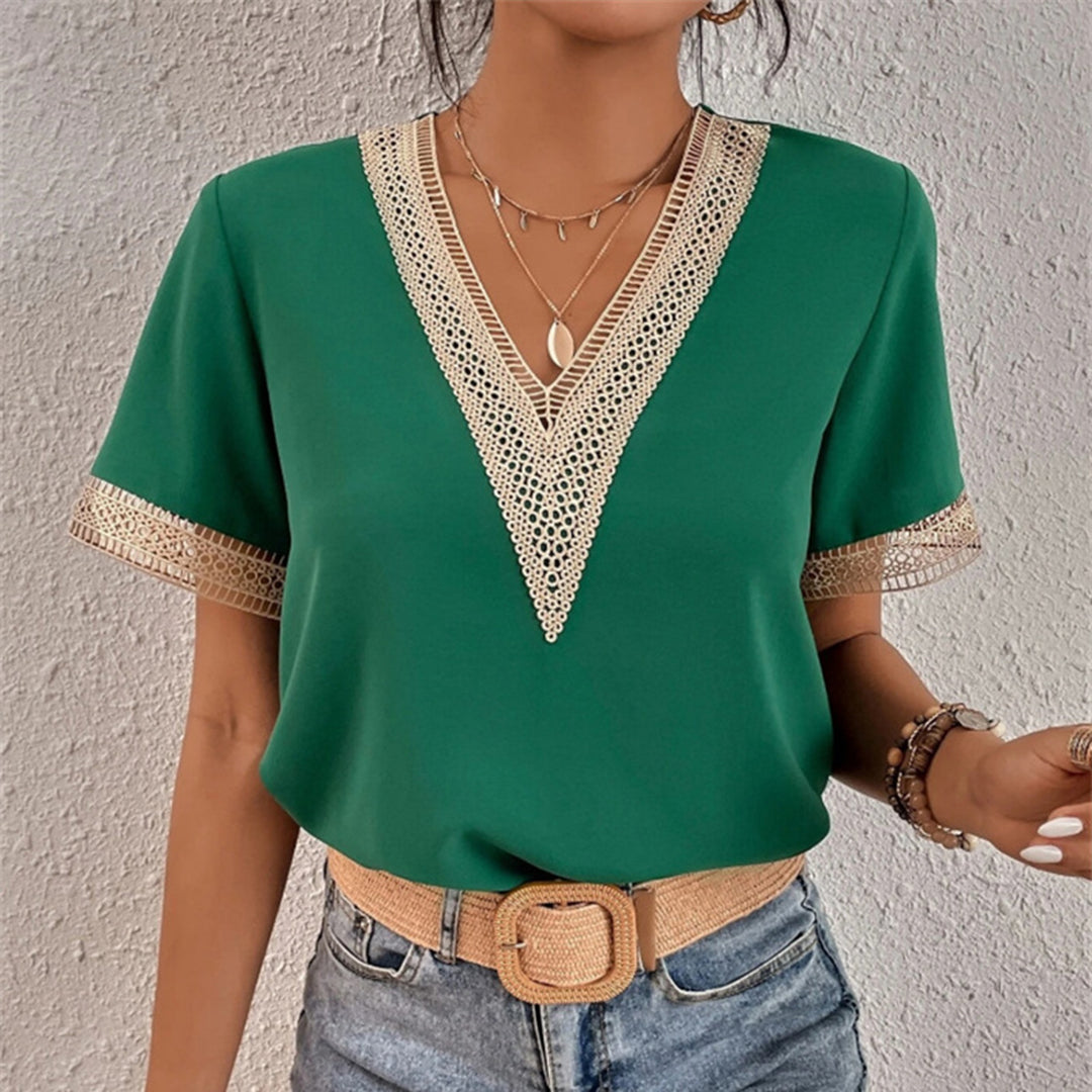 Frau in grünem V-Ausschnitt-Top mit Spitze, Jeans, Gürtel, Schmuck, modisch, elegant.