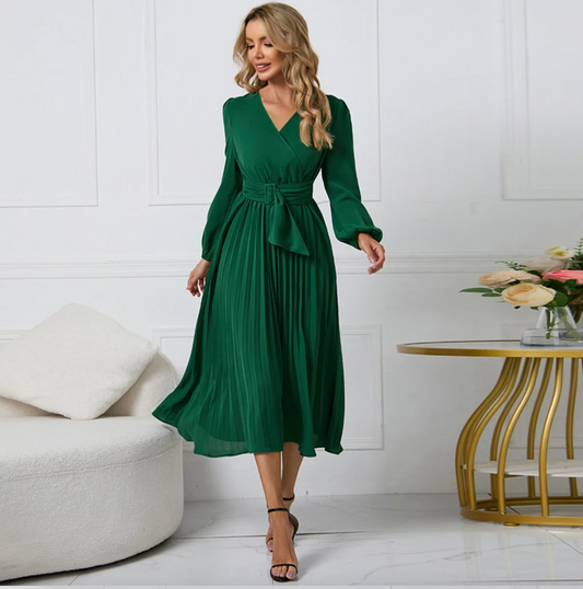 Frau in grünem Kleid, elegantes Design, langärmelig, Plissee, Wohnzimmer, Modefotografie.