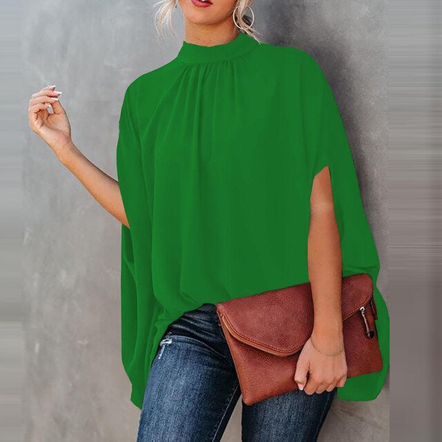 Frau in grüner Batwing-Bluse, Jeans, braune Tasche, modisch, lässig, Frühling-Sommer-Look.