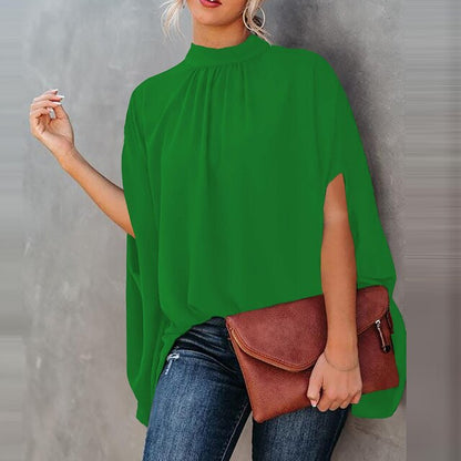 Frau in grüner Batwing-Bluse, Jeans, braune Tasche, modisch, lässig, Frühling-Sommer-Look.