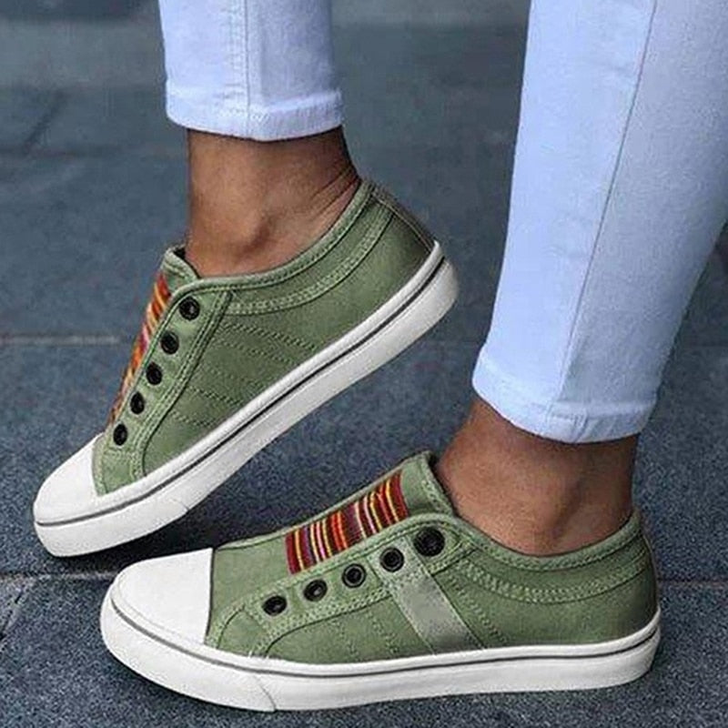 Grüne Sneaker mit weißer Sohle, gestreiftem Detail, Damenmode, Freizeitschuh, Straßenstil.