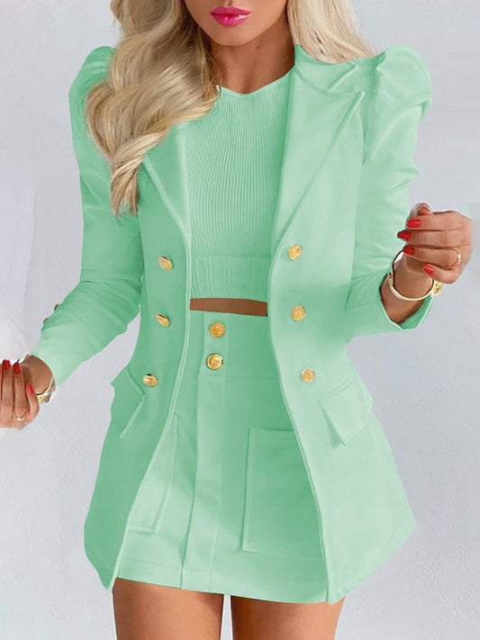 Frau in mintgrünem Blazer und Rock, elegantes Outfit, modische Damenbekleidung, goldene Knöpfe.