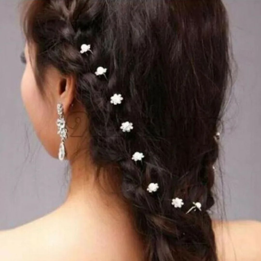 Frau mit geflochtenem Haar, verziert mit weißen Blumen-Haarspangen, eleganter Look.