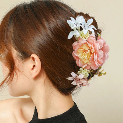 Frau mit Haarklammer, rosa und weiße Blumen, elegantes Haaraccessoire, Hochsteckfrisur.